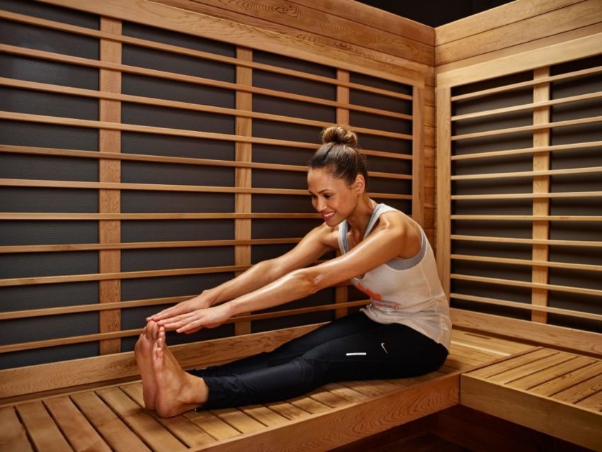 Une femme fait du stretching dans un sauna infrarouge